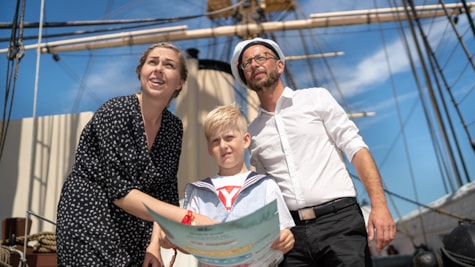 Familie står på dækket på Fregatten Jylland med skattekort