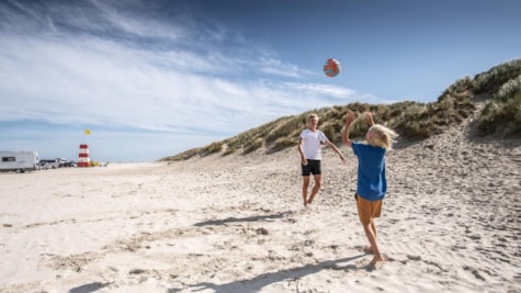 Drenge spiller bold på stranden