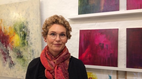 Kunstner Tine Mynster foran sine malerier