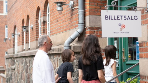 En mand, kvinde, mor, far og børn går ind af hovedindgangen ved Industrimuseet i Horsens