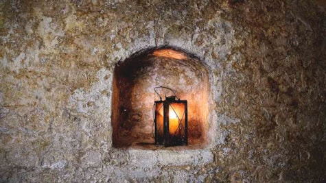 En lampe i en af de gamle tilmurede vinduer i kælderen