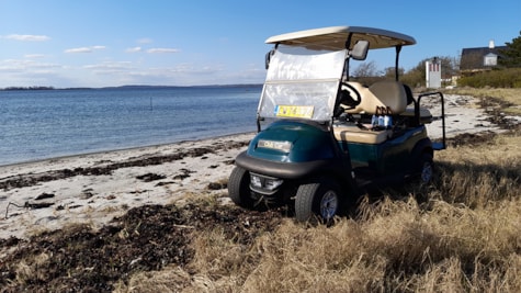 Golfbil på stranden i solskinsvejr