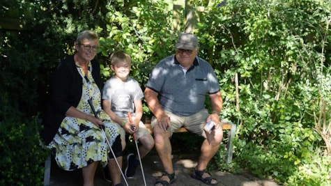 Farmor, farfar og barnebarn venter på at det bliver der tur i minigolf