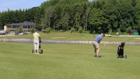 To golfspillere med Douglashuset og Langesøskoven i baggrunden