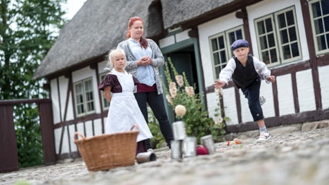 dreng og piger har historisk tøj på og leger på Gludmuseum