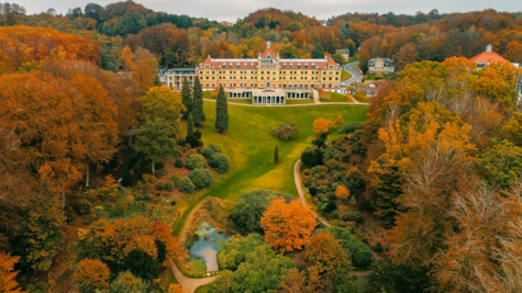 Dronefoto af Hotel Vejlefjord og parken i efterårsfarver